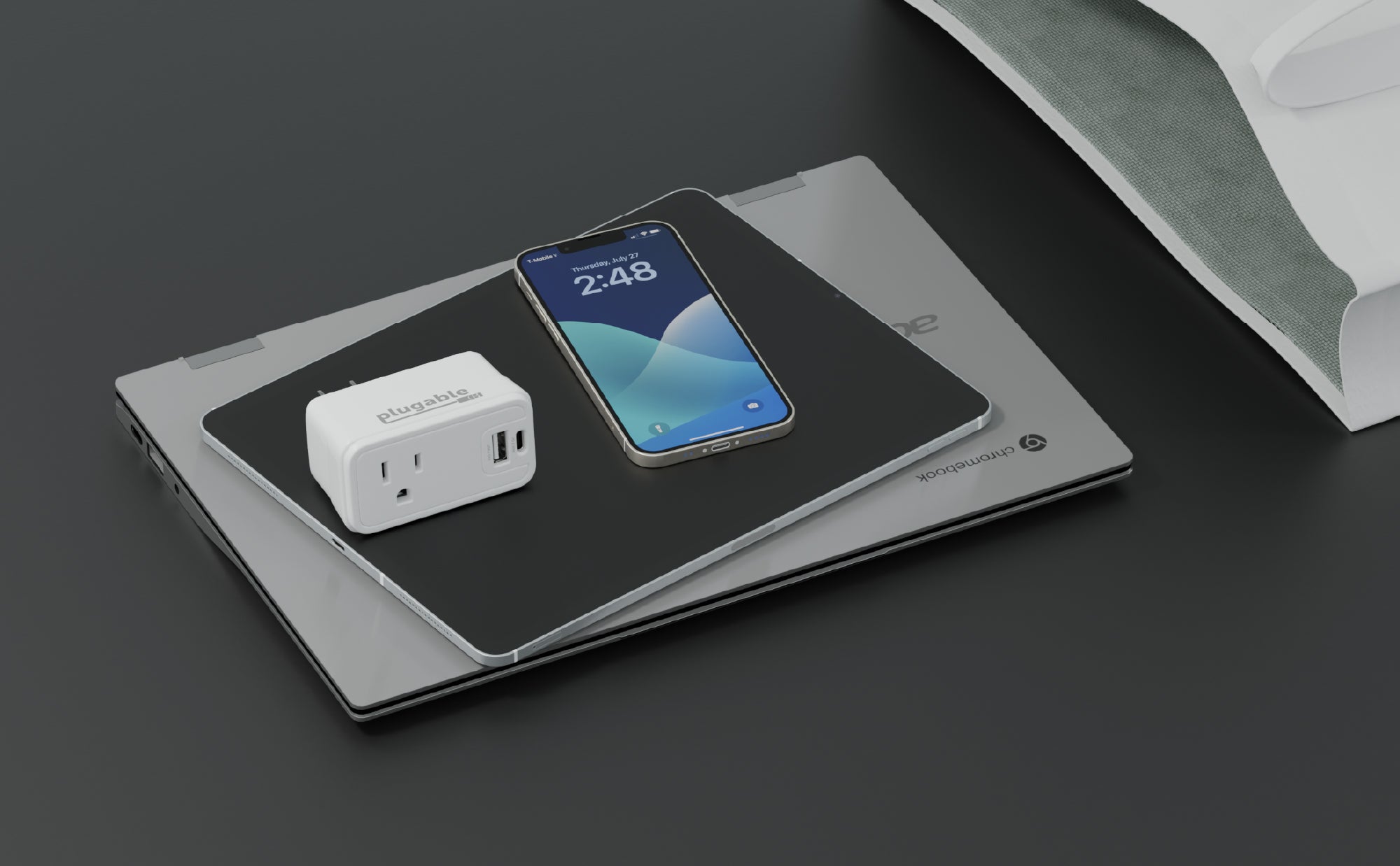 A image of the PS1-CA1 pass through outlet charger next to an iPhone, a tablet, and a Chromebook.
