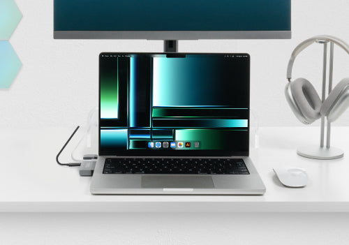 Image of a desk setup with a MacBook and a monitor connected to the AMS-5IN1E