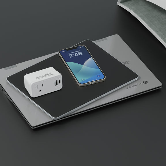 A image of the PS1-CA1 pass through outlet charger next to an iPhone, a tablet, and a Chromebook.
