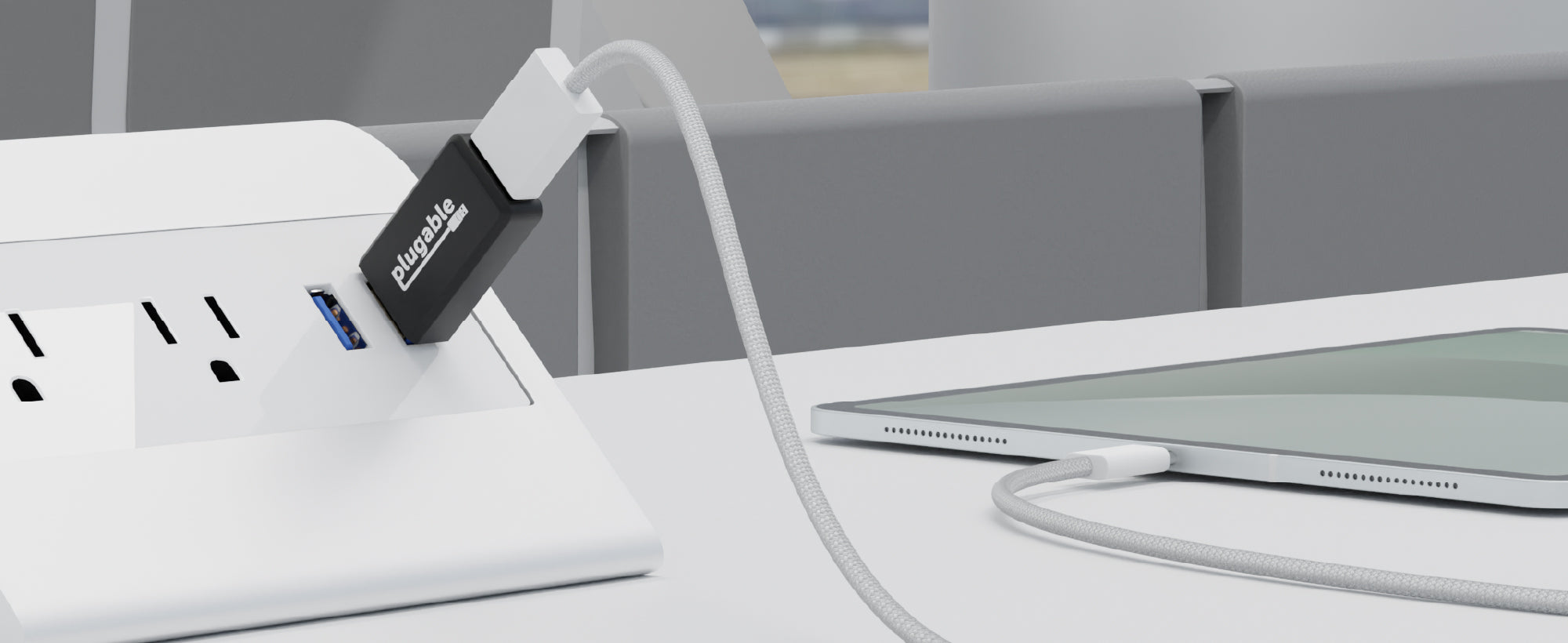 An image of one of the USB-MC1-5X 5-pack. It is plugged into a public USB port, with a tablet plugged into it for secure charging