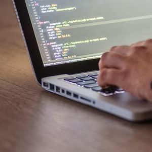 An image of someone writing code on a laptop.